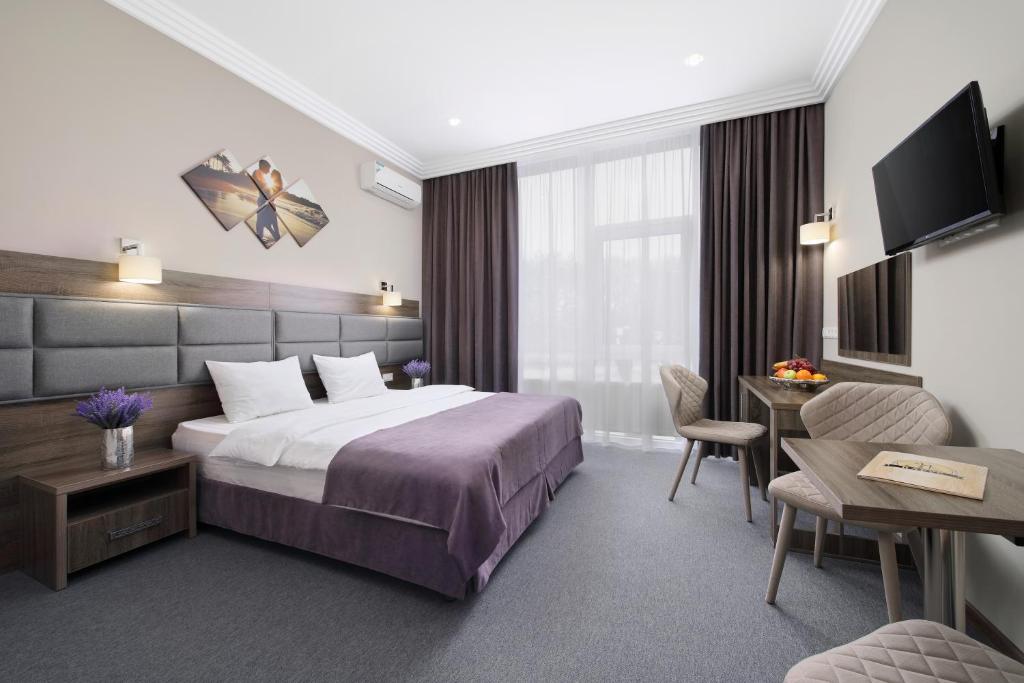 ピャチゴルスクにあるParus SPA-Hotelのベッドとデスクが備わるホテルルームです。