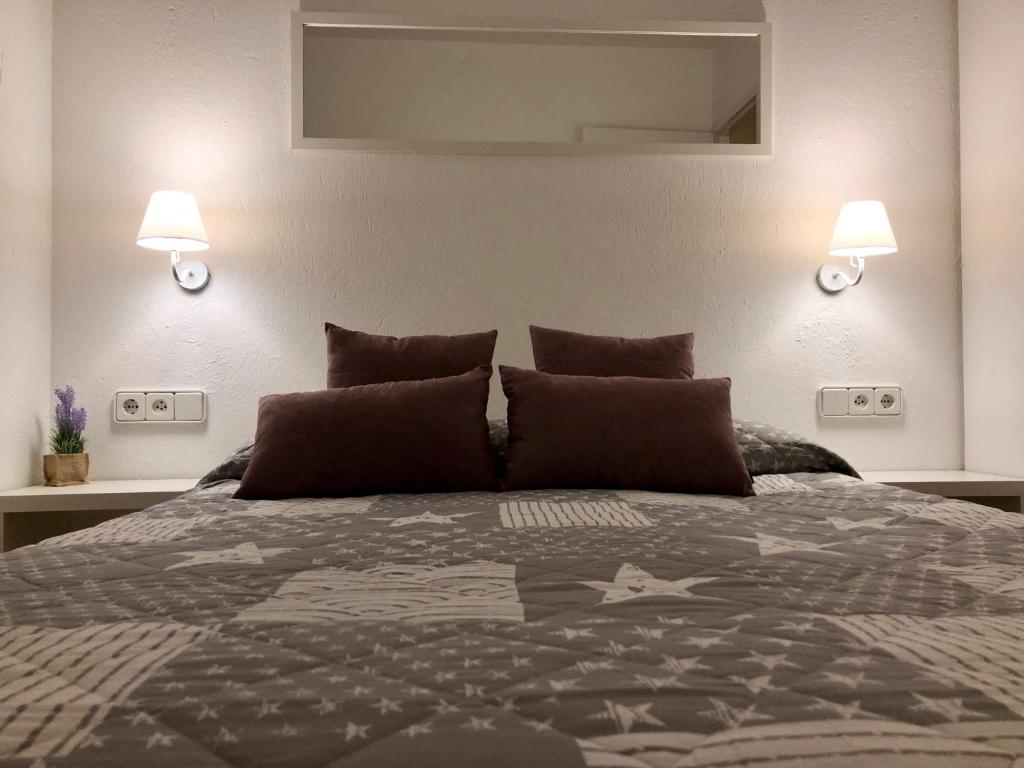 a bedroom with a large bed with two lamps at Apartaments S'Arenella in Cadaqués