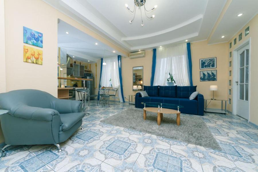 キーウにあるApartment Pushkinskayaのリビングルーム(青いソファ2台、テーブル付)