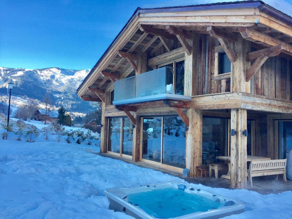 Cabaña de madera con bañera de hidromasaje en la nieve en Chalet Alexandra en Les Houches