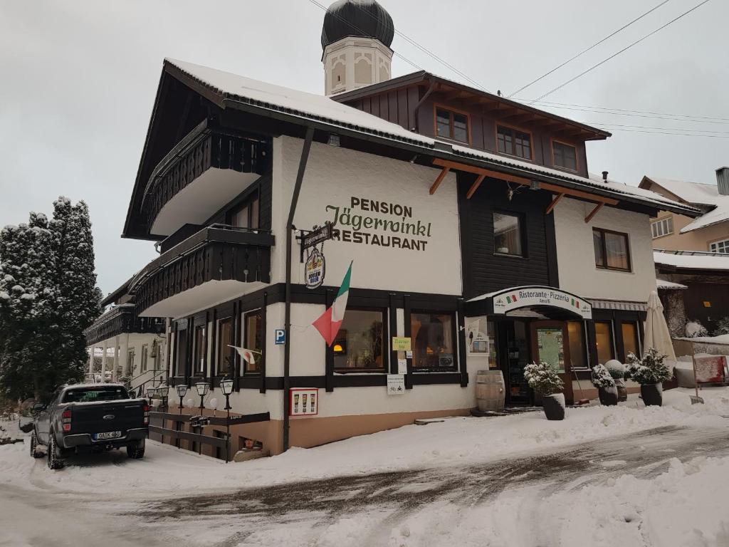 a building with a truck parked in front of it at Pension – Restaurant Jägerwinkl in Rettenberg