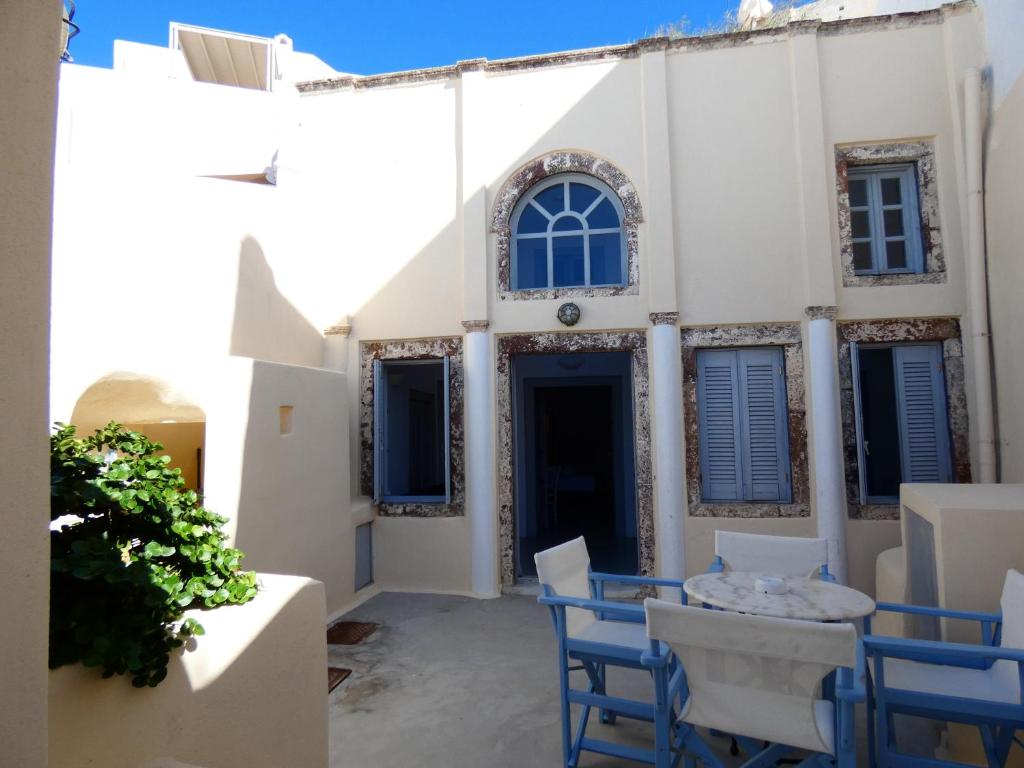 a patio in front of a white building with blue chairs at Pantelia Pyrgos in Pirgos