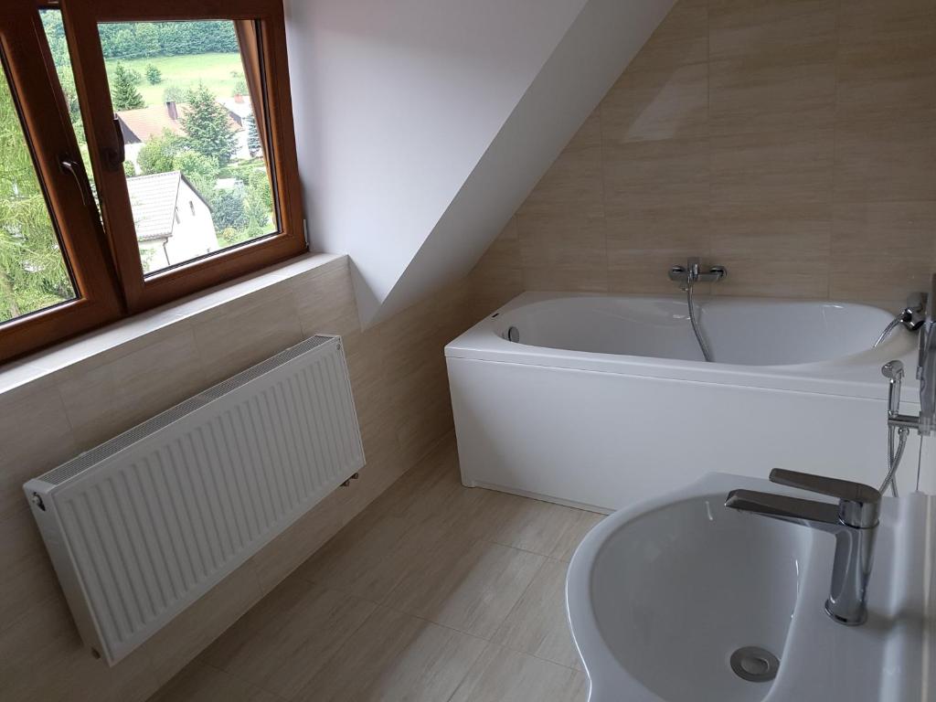 a bathroom with a bath tub and a sink at Podgórzanka in Kaczorów