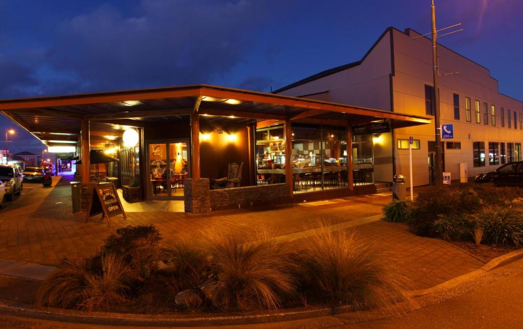 a building with a restaurant in front of it at night at Stumpers Hotel in Hokitika