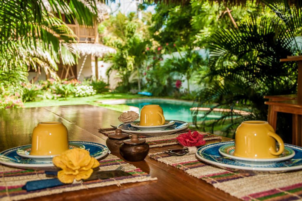 a table with three yellow cups and plates on it at Residence Bons Ventos Jeri in Jericoacoara