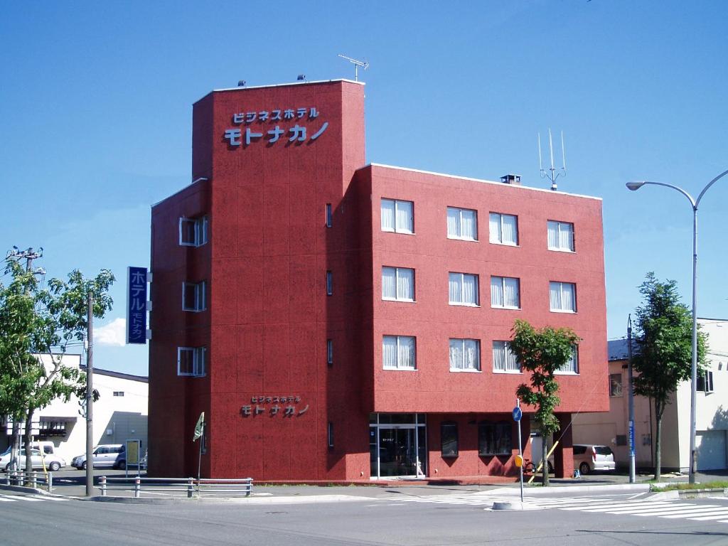un edificio rojo con escritura en el costado. en Business Hotel Motonakano, en Tomakomai