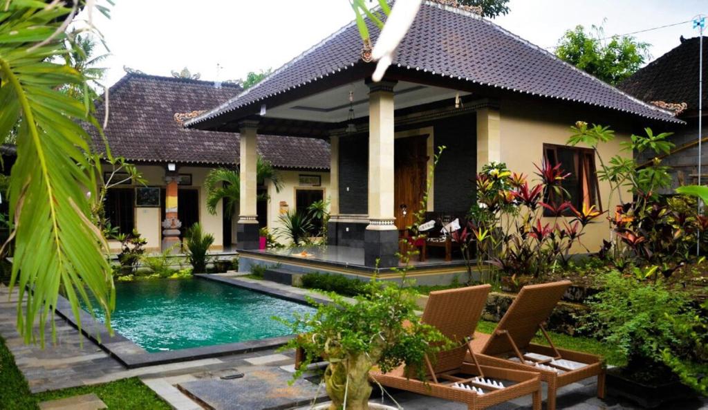 une maison avec une piscine en face de celle-ci dans l'établissement Teba Junjungan Cottages, à Ubud