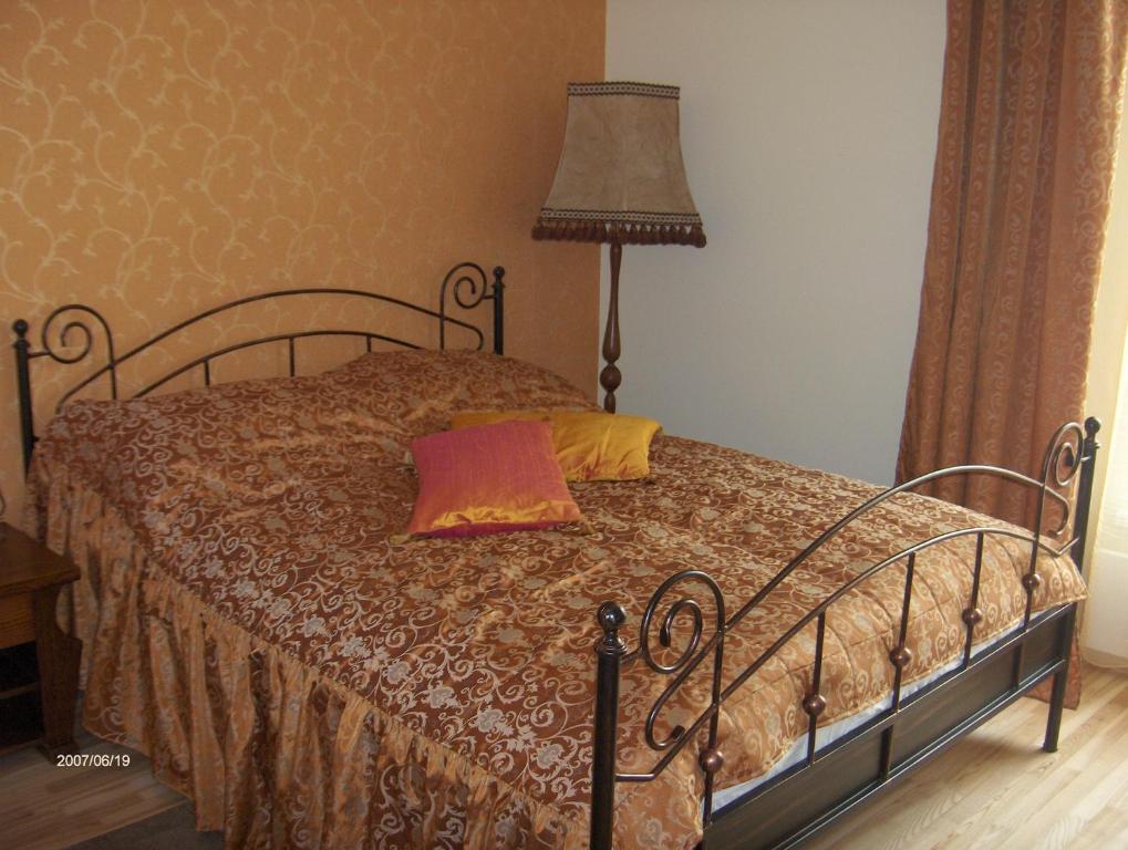 um quarto com uma cama com um candeeiro em Hotel Centras em Šakiai