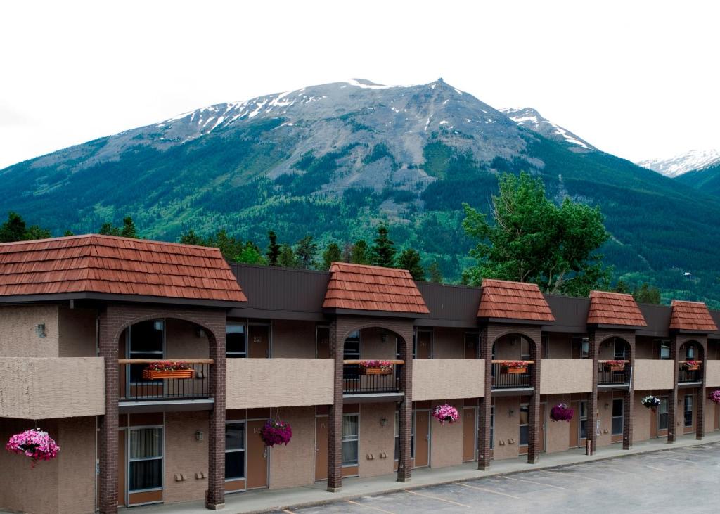 un edificio con una montaña en el fondo en Maligne Lodge, en Jasper