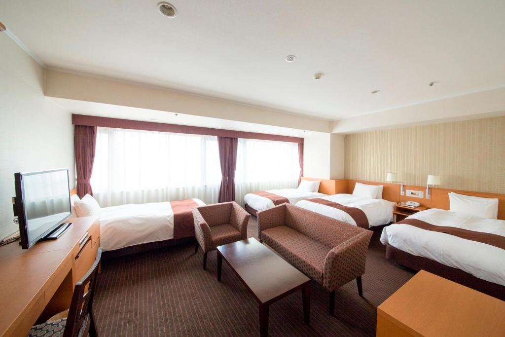 Postel nebo postele na pokoji v ubytování Meitetsu Grand Hotel