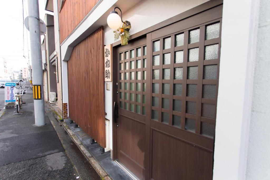 een paar houten garagedeuren op een gebouw bij Kanesuke Kyoto in Kyoto