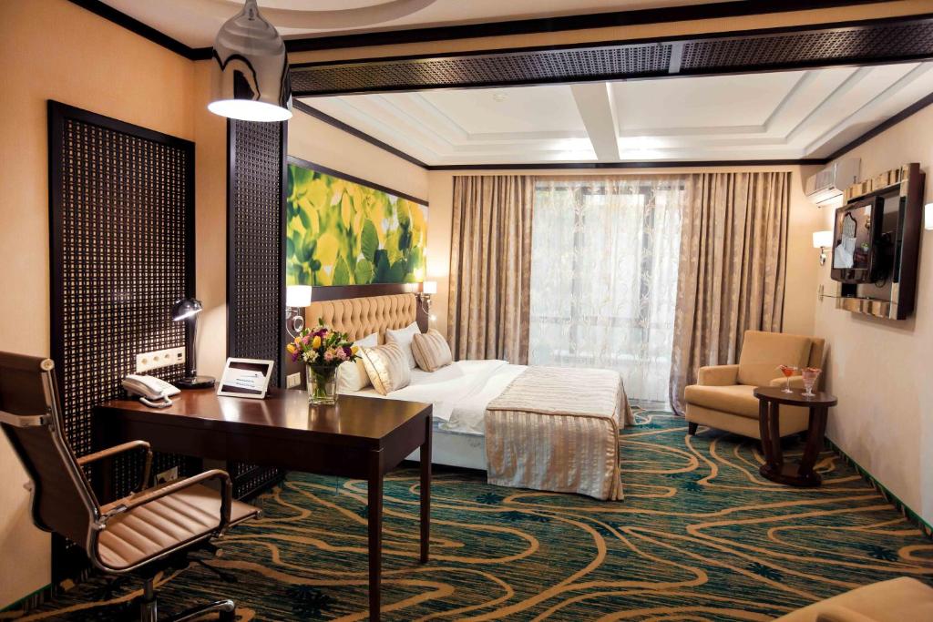 a hotel room with a bed and a desk at Hotel Kazzhol Almaty in Almaty