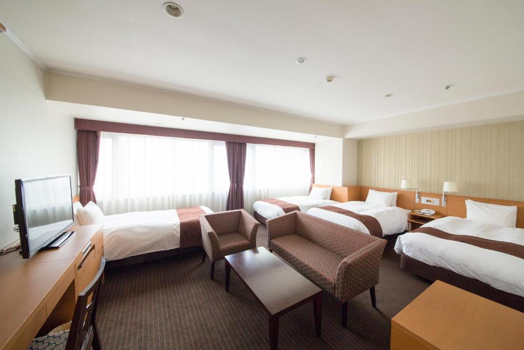 Postel nebo postele na pokoji v ubytování Meitetsu Grand Hotel