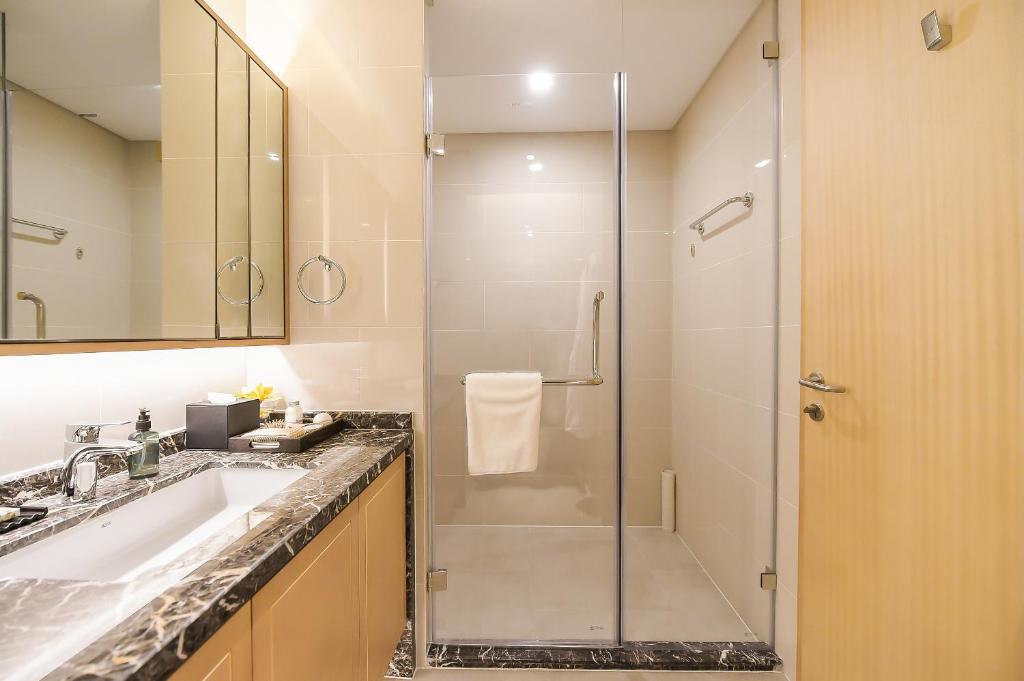 a bathroom with a shower and a sink at Somerset Harmony City Wuxi in Wuxi