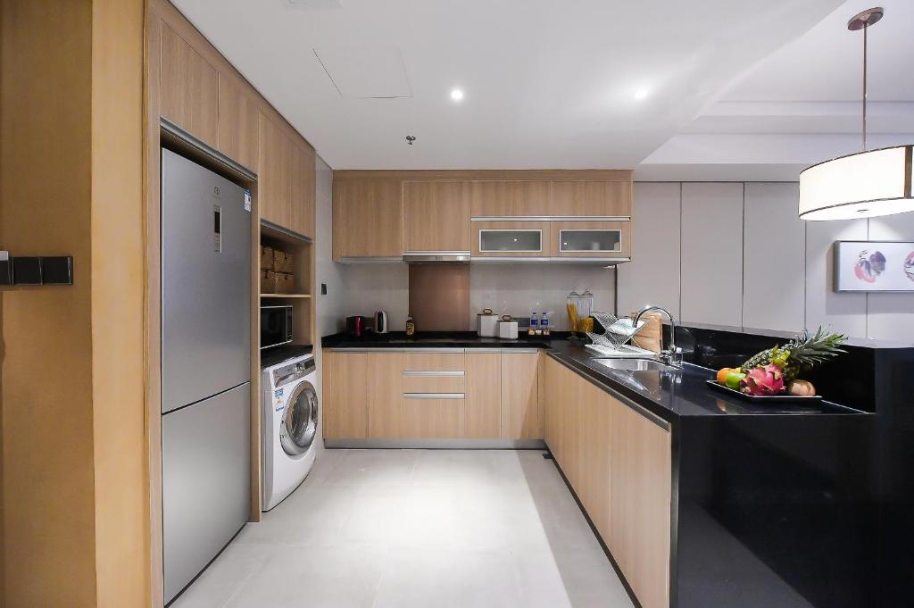 a kitchen with a refrigerator and a washer and dryer at Somerset Harmony City Wuxi in Wuxi