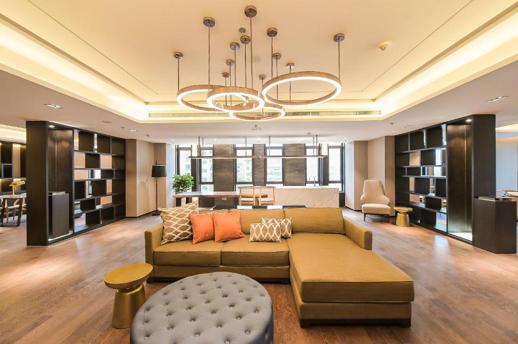 a living room with a couch and a table at Somerset Harmony City Wuxi in Wuxi