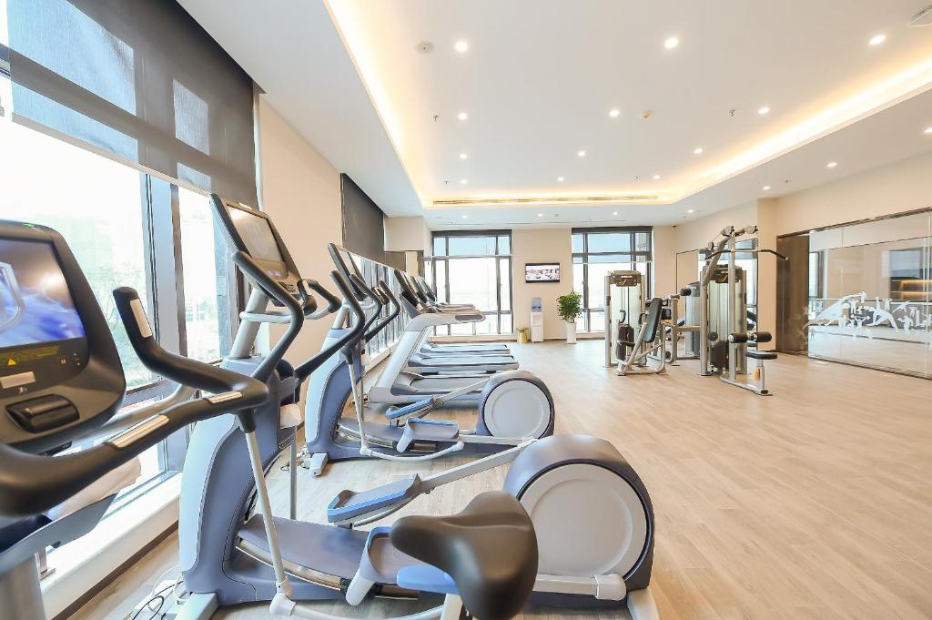 a gym with rows of treadmills and elliptical machines at Somerset Harmony City Wuxi in Wuxi
