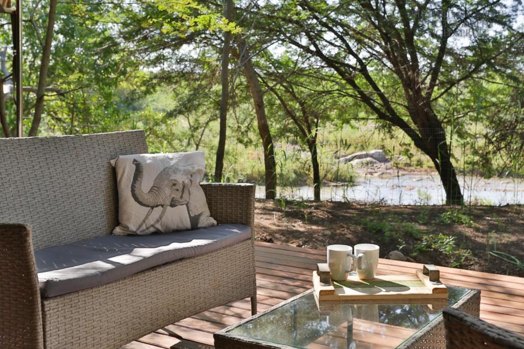 a patio with a couch and a glass table at Southern Sands Eco Lodge in Hoedspruit