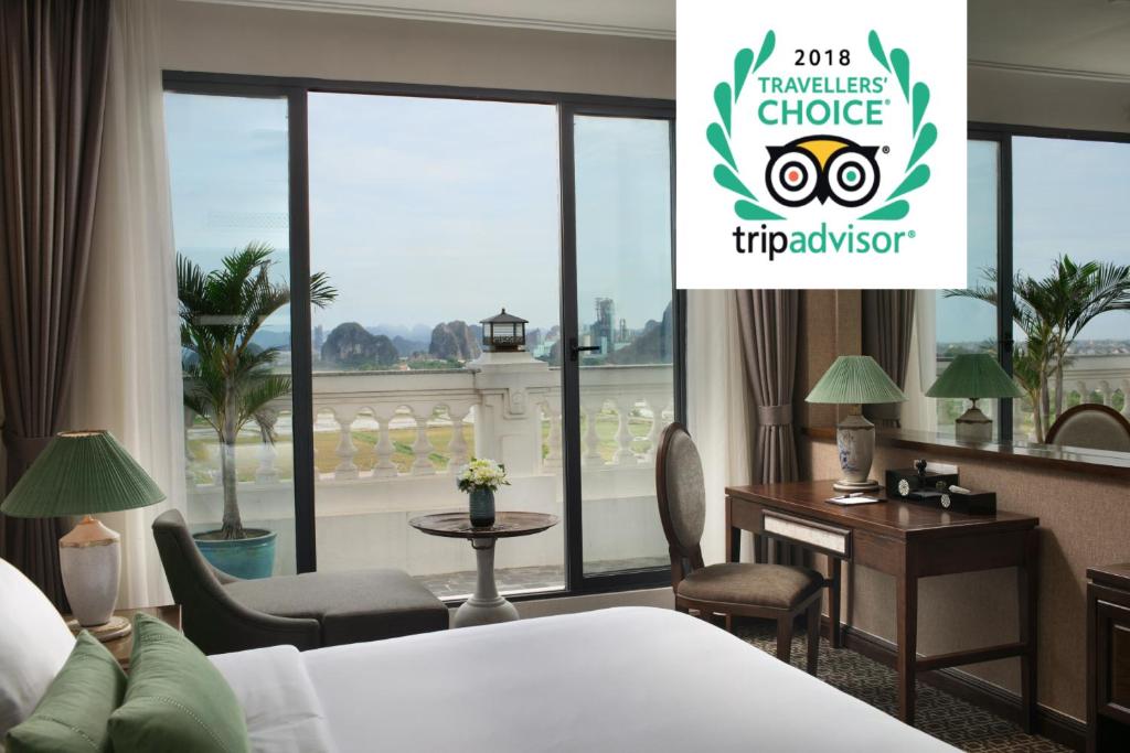 una camera d'albergo con letto, scrivania e finestra di Ninh Binh Hidden Charm Hotel & Resort a Ninh Binh