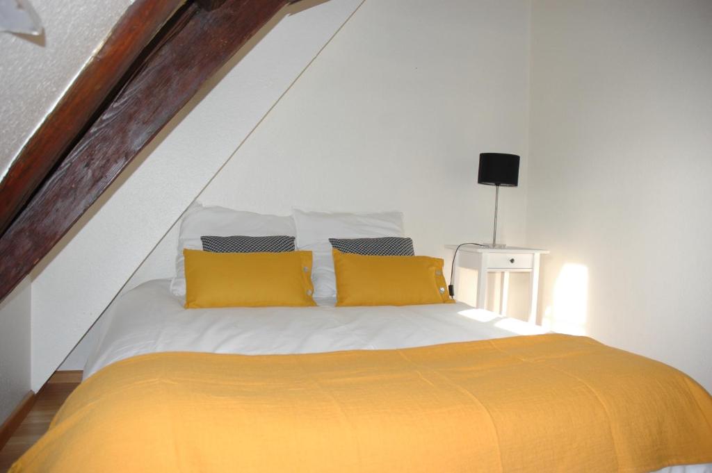 a bedroom with a bed with yellow pillows at appartement à Colmar in Colmar