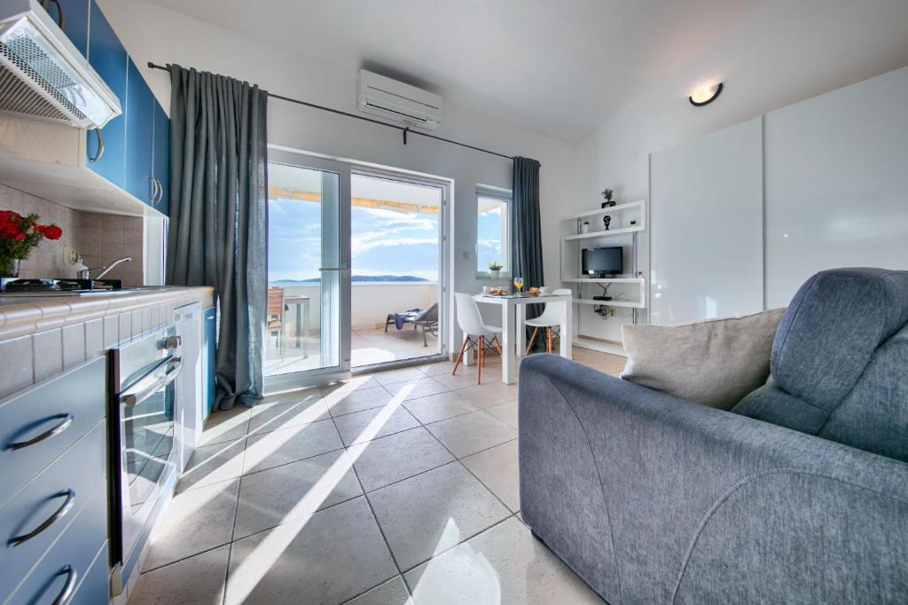 a kitchen and living room with a couch and a table at Seafront Suites Maja in Vis