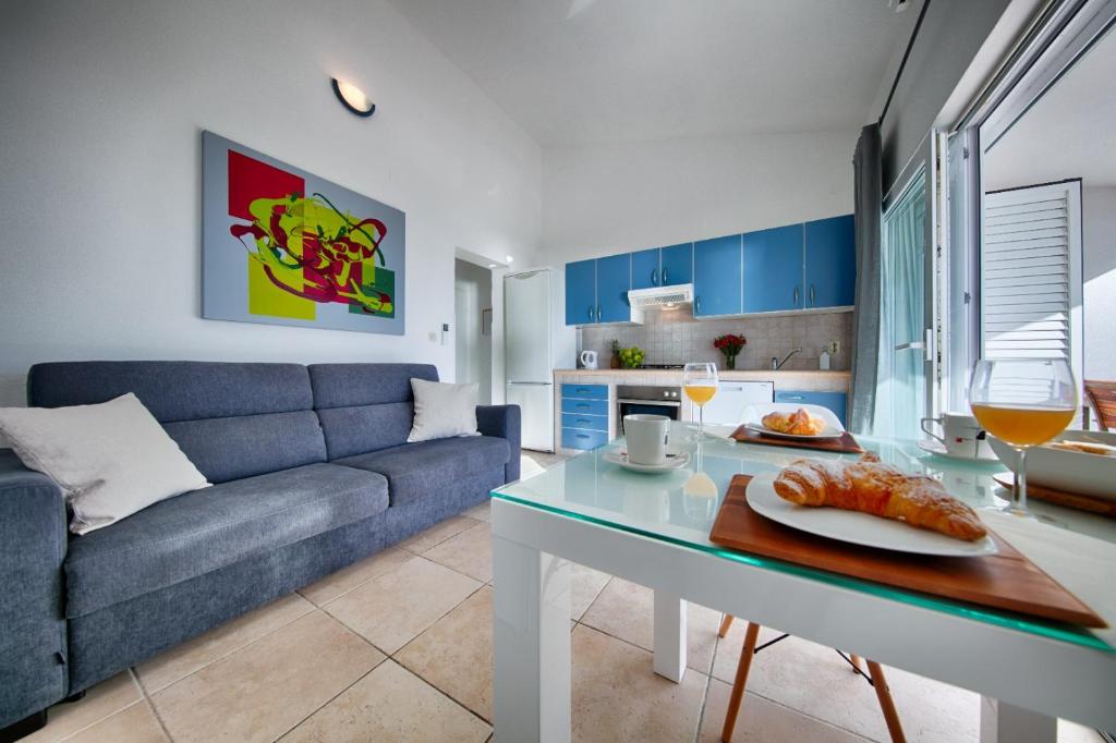 a living room with a blue couch and a table at Seafront Suites Maja in Vis