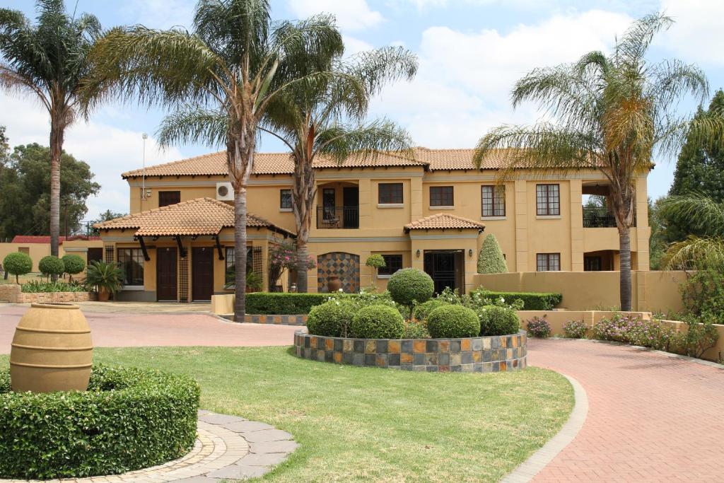 米德蘭的住宿－La Villa Rosa，前面有棕榈树的房子