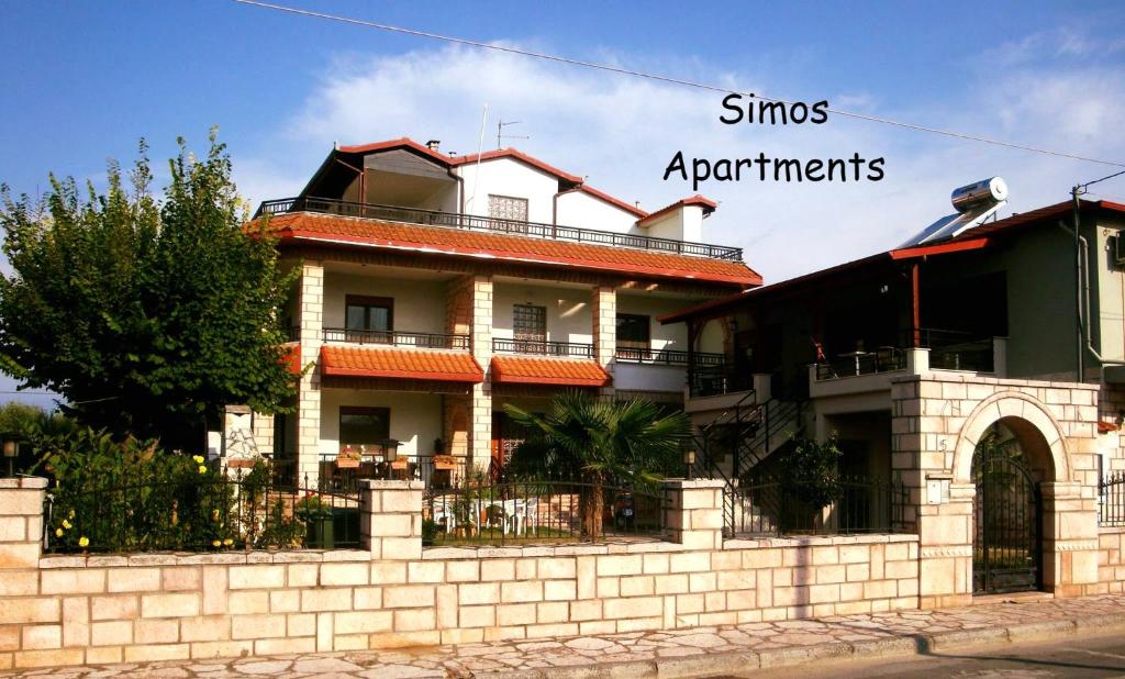 een gebouw met de woorden sims en appartementen aan de zijkant bij Simos Apartments in Korinós