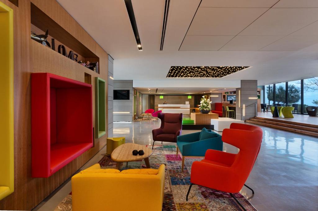 a lobby with colorful chairs and a living room at Haifa Bay View Hotel By AFI Hotels in Haifa