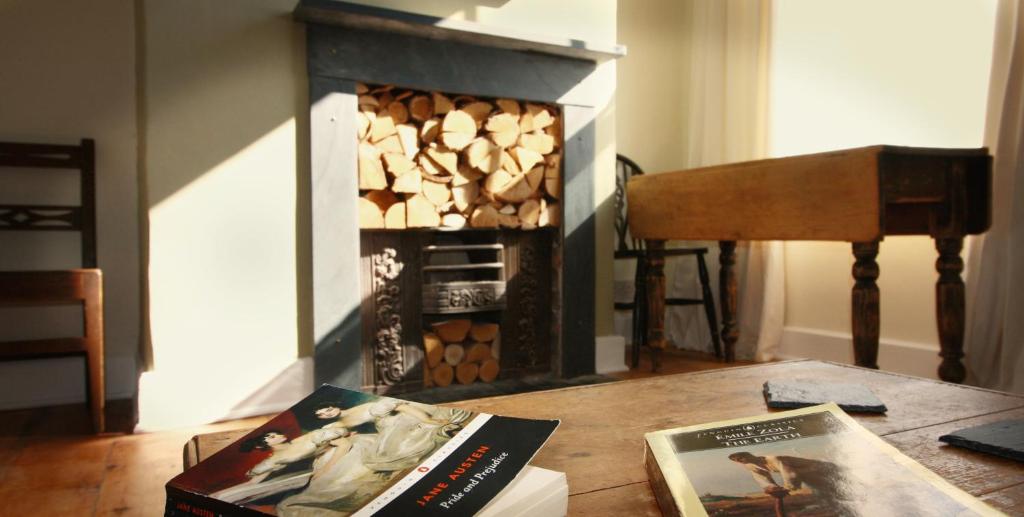 a table with a book and a fireplace at 20 Segontium Terrace in Caernarfon