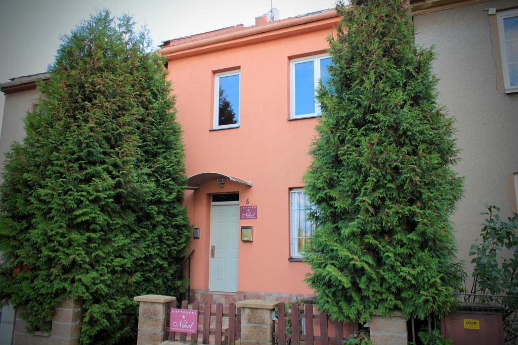 una casa con dos árboles delante de ella en Ubytovani Nikol en Brno