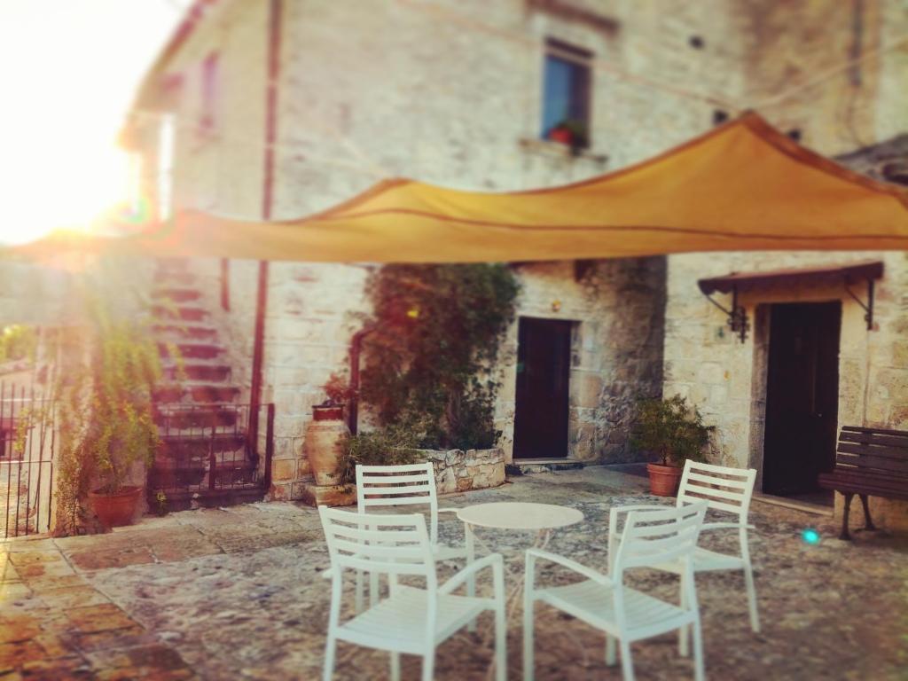 uma mesa e cadeiras em frente a um edifício em Le Case Di S. Andrea em Buccheri