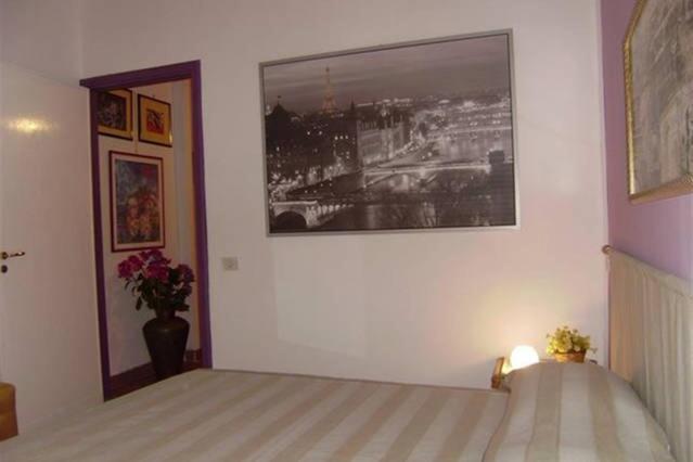 sypialnia z łóżkiem z obrazem na ścianie w obiekcie Cosmopolitan B&B w Rzymie