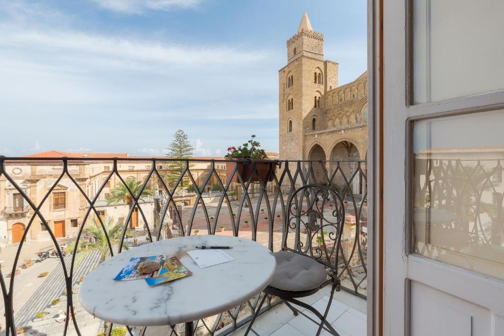 a balcony with a table and a view of a building at Palazzo Maria in Cefalù