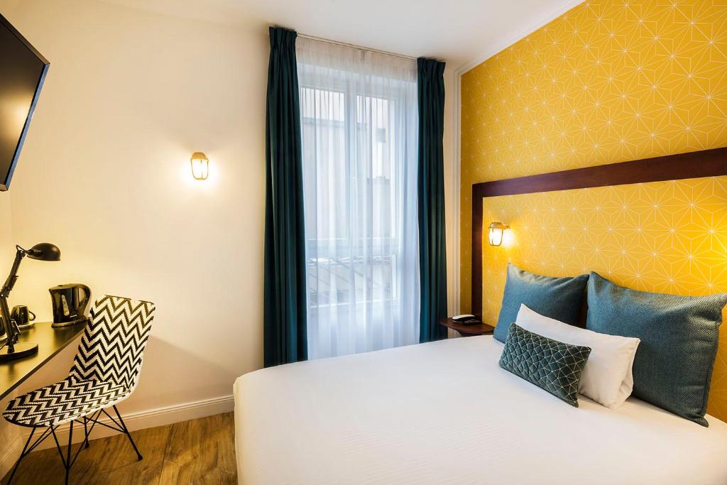 a bedroom with a bed and a chair and a window at Hotel The Playce by Happyculture in Paris