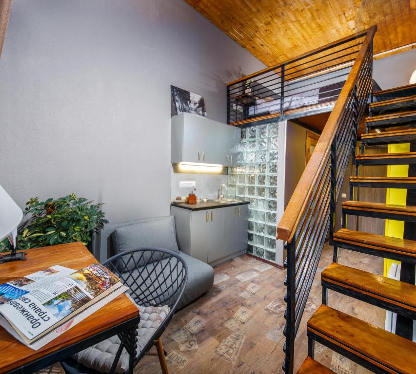 a living room with a staircase and a table and chair at Mezzanine Hotel in Odesa