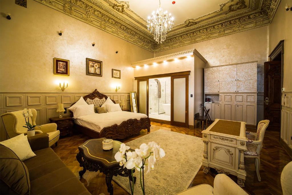 Hotel 5 Continents في كرايوفا: غرفة نوم بسرير واريكة وطاولة