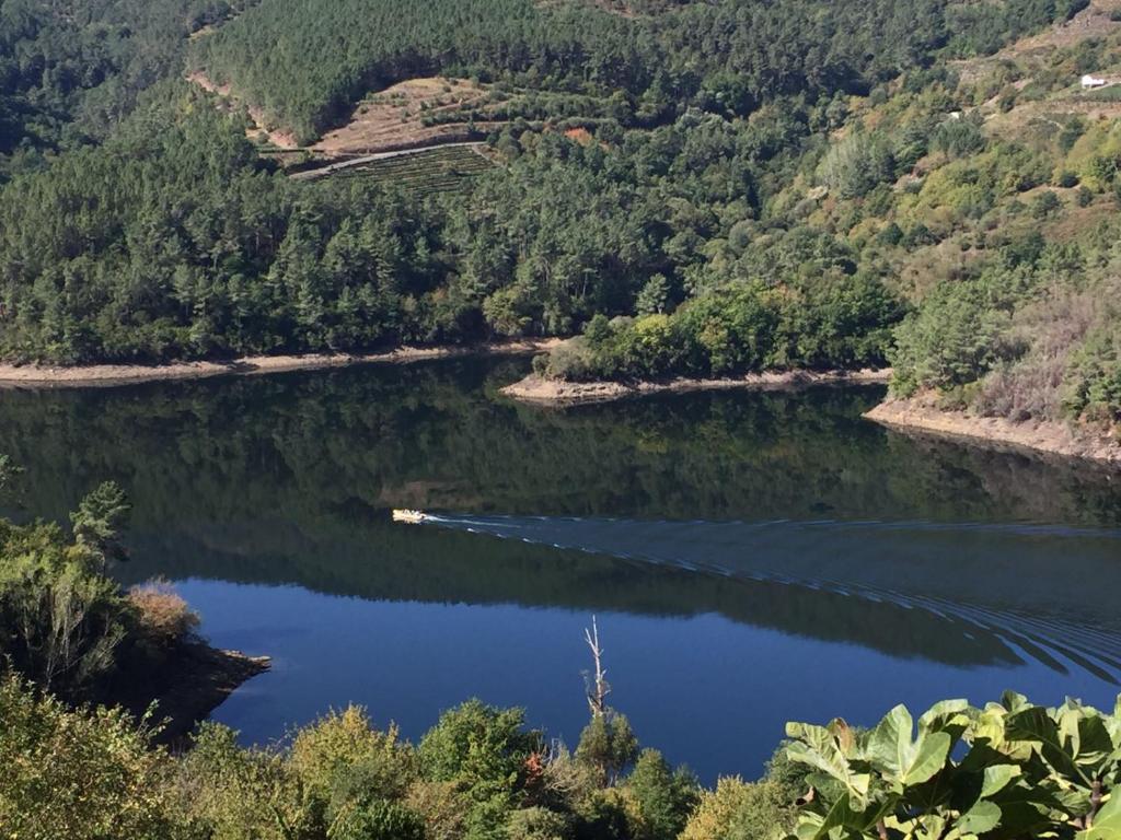 Elle offre une vue sur un lac avec un bateau. dans l'établissement Casa Campacinas Casas Vacacional con vistas del rio, à O Carballo