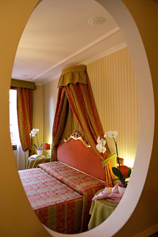 a bedroom with a bed with a red canopy at Hotel Kette in Venice