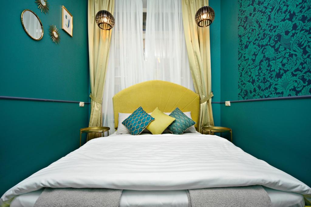 a bedroom with a large bed with blue walls at Guest House Yum Yum in Moscow