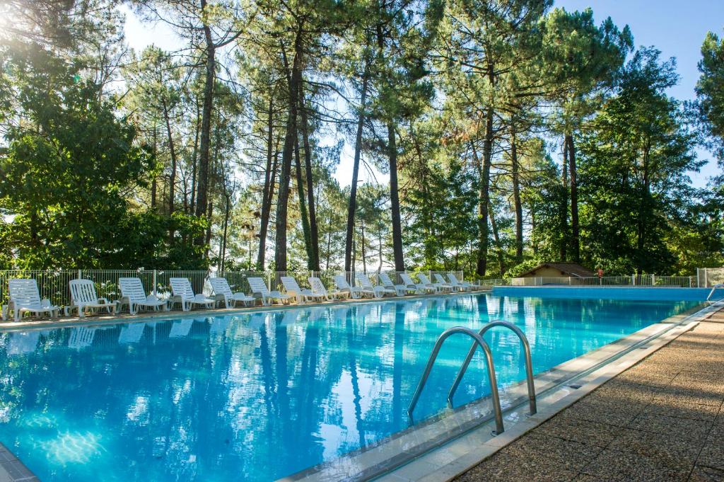 a large swimming pool with chairs and trees at VTF La Croix de Vinchannes in Joyeuse