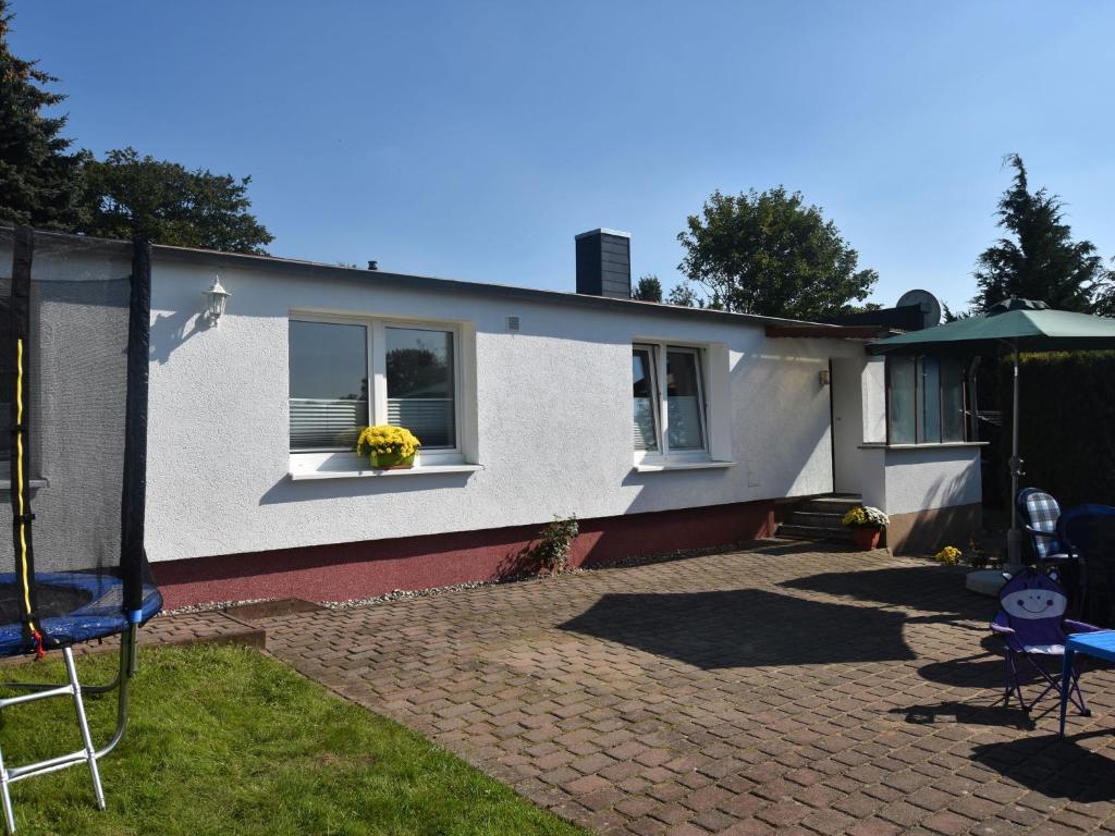 a white house with two windows and a patio at Modern Bungalow in Kr pelin with Garden in Kröpelin