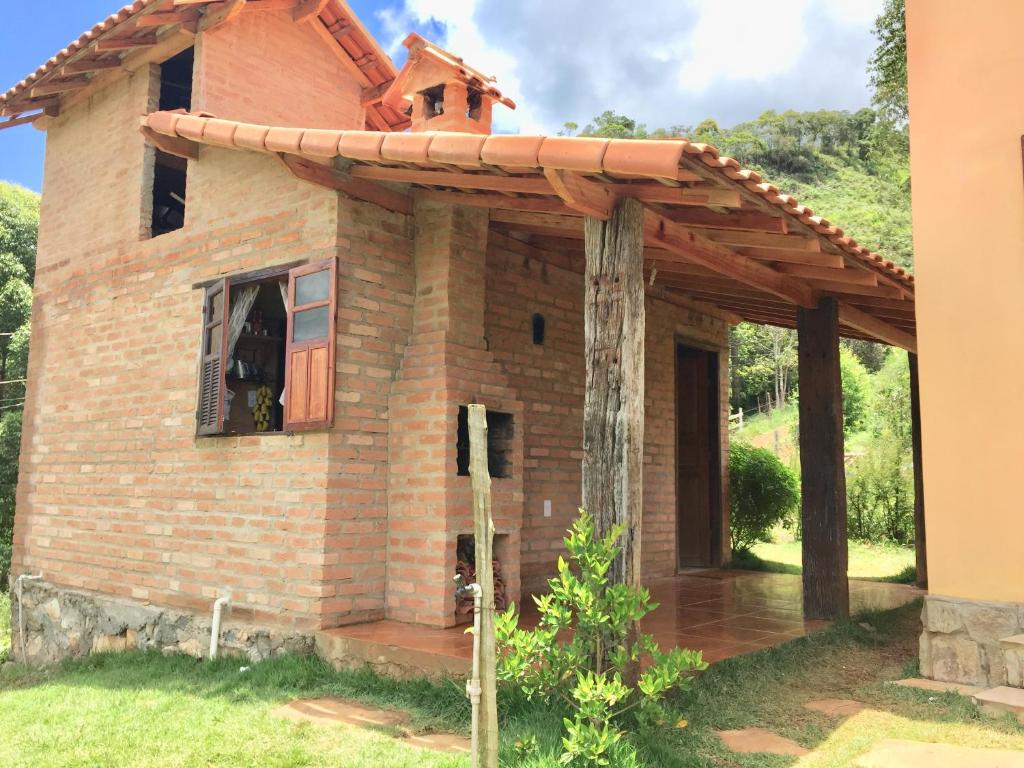 an outside view of a house with a wooden roof at Chalé Ibiti in Conceição da Ibitipoca