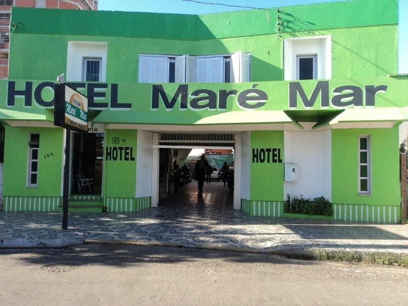 un bâtiment vert et blanc avec un panneau sur celui-ci dans l'établissement Mare Mar, à Tramandaí