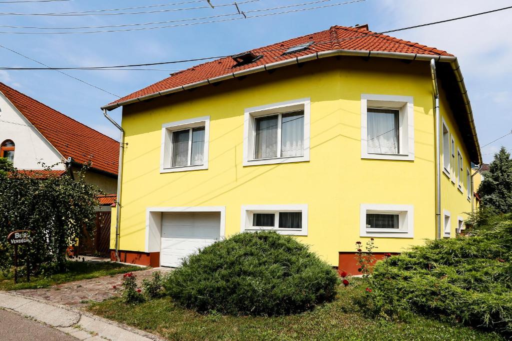 a yellow house with a red roof at Burg Vendégház in Eger