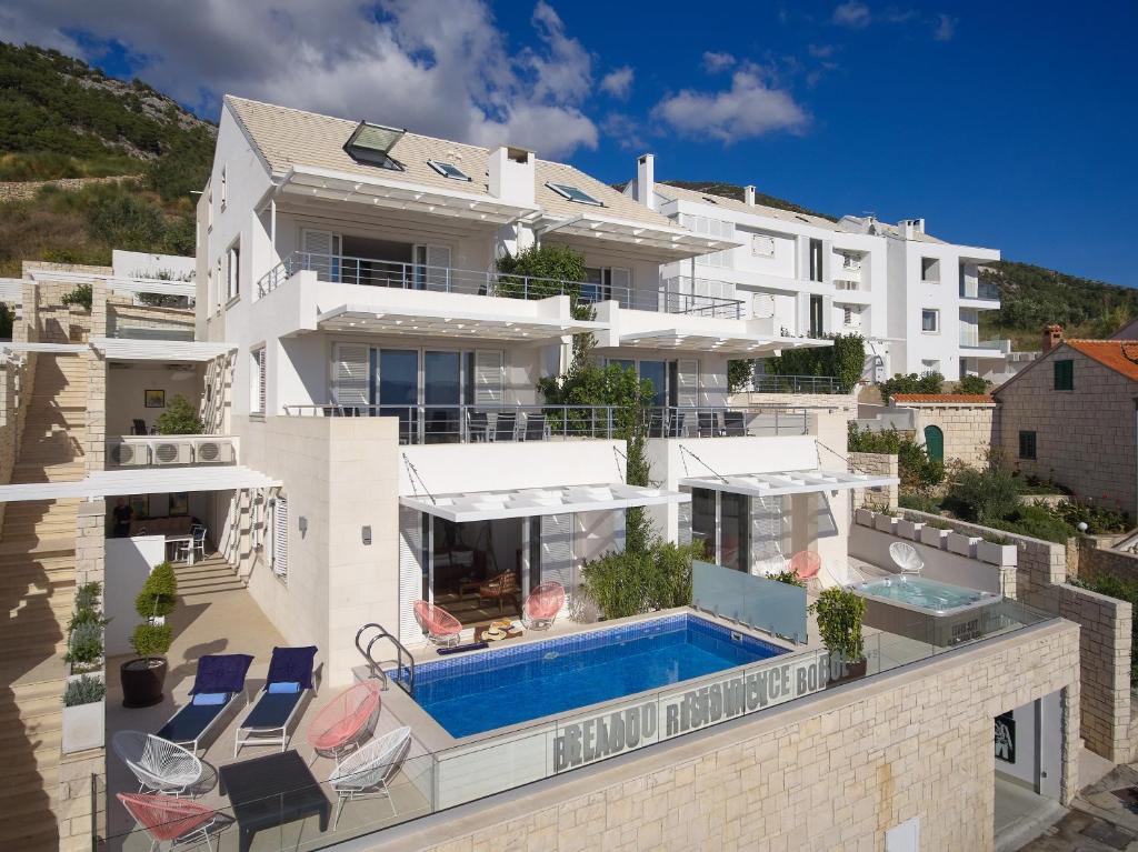 a large white building with a swimming pool on a balcony at Belado Residence Bol in Bol