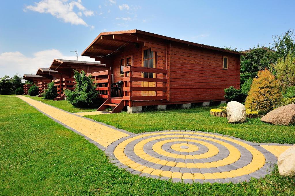 a stone pathway in front of a house at Domki Rybka in Sarbinowo