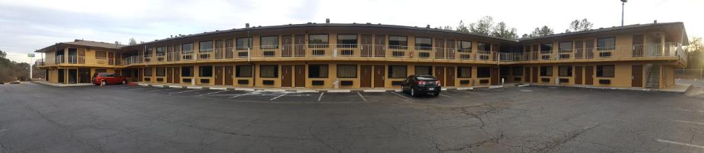 ein großes Gebäude mit einem Motorrad auf einem Parkplatz in der Unterkunft America's Best Inn - Macon in Macon