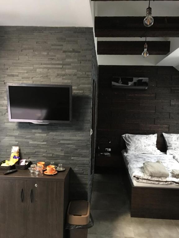 a bedroom with a bed and a tv on a brick wall at Apartmán na Studentské in Karviná