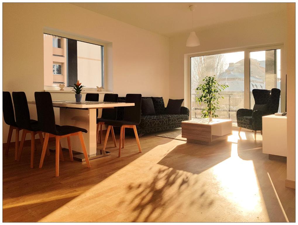 een woonkamer met een tafel en stoelen en een bank bij Central Comfort Suites in Braşov